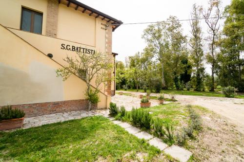 Una casa con un cartel en el costado. en Agriturismo Bio San Mamiliano, en Grosseto