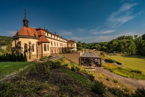 ein großes Gebäude mit einem Turm auf einem Feld in der Unterkunft Wellness & spa hotel Augustiniánský dům in Luhačovice