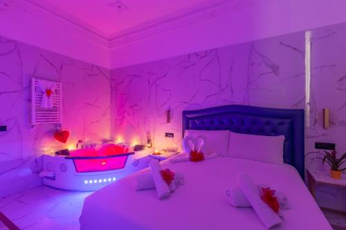 ein Schlafzimmer mit einem Bett und einer Badewanne mit rosa Lichtern in der Unterkunft Miss Suite in Rom