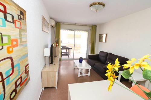 een woonkamer met een bank en een tafel bij DIFFERENTFLATS Palafox in Salou