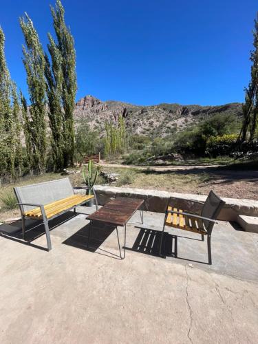 a picnic table and a bench and a table at Bello Atardecer in Tilcara