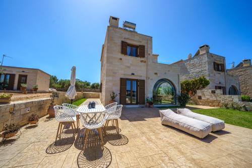 un patio con mesa y sillas y un edificio en FOS residence - ΦΩΣ ,luxury villa, en La Canea