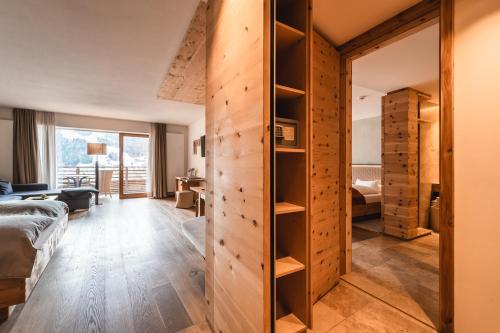 1 dormitorio con puerta corredera que da a una habitación en Naturhotel Leitlhof, en San Candido