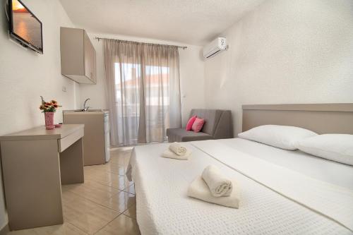 um quarto com uma grande cama branca e uma cozinha em Studio & Apartments More em Neum