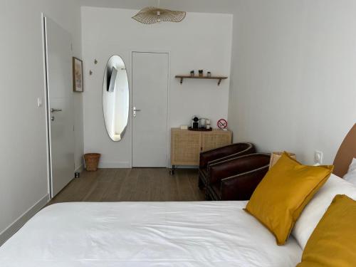 una camera con letto, cuscino giallo e sedia di Great Room 29 a Mérignac