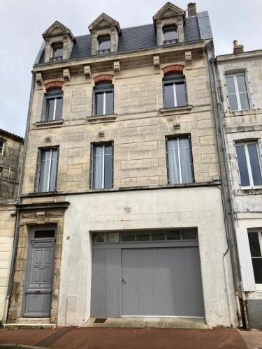 an old brick building with two garage doors at Beau T3 lumineux : La Couronne in Rochefort