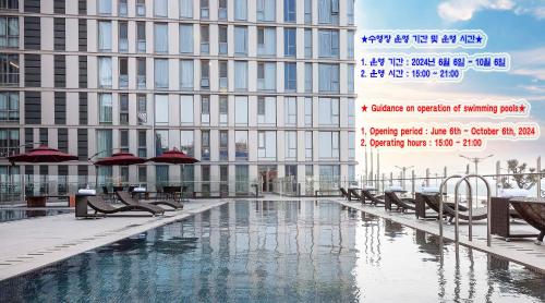 ein großes Gebäude mit einem Pool vor einem Gebäude in der Unterkunft Hotel Regent Marine The Blue in Jeju-do