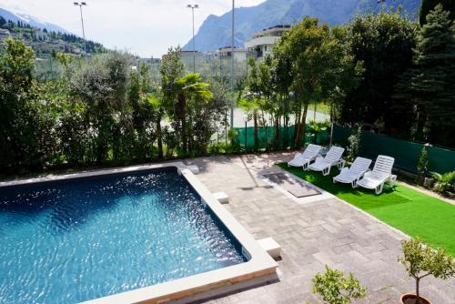 - une piscine avec des chaises longues à côté d'une cour dans l'établissement Hotel Diana, à Riva del Garda