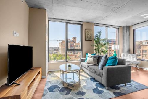 a living room with a couch and a flat screen tv at 3BR Elegant Glass Penthouse Pool With Deck & Gym in Chicago