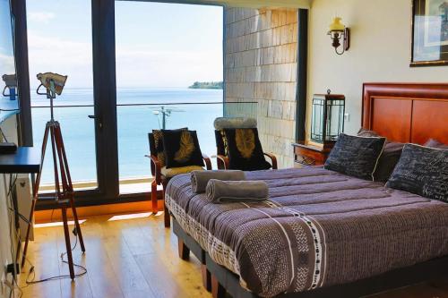 1 dormitorio con 1 cama y vistas al océano en HOM I Hermoso Depto3D2B con parking vista al lago Pto Varas, Sin calefacción, en Puerto Varas