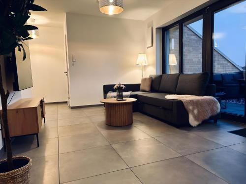 a living room with a couch and a table at FeWo Am Povelturm - mit Aufzug und großer Loggia in Nordhorn