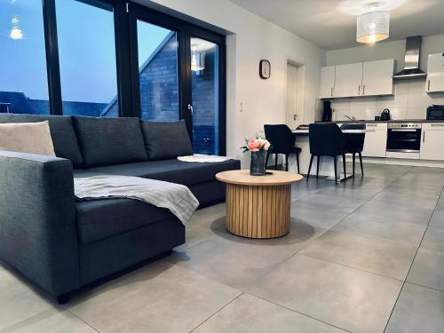 a living room with a couch and a table at FeWo Am Povelturm - mit Aufzug und großer Loggia in Nordhorn