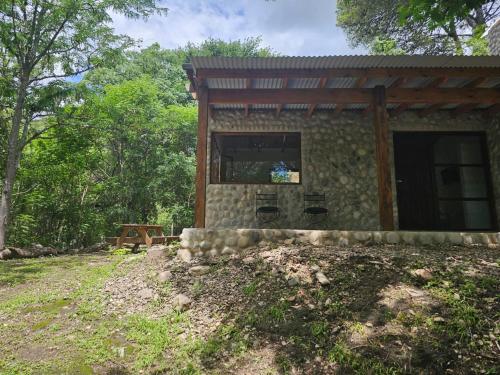 uma pequena casa de pedra no meio de uma floresta em Las Casitas de Piedra I em Villa General Belgrano