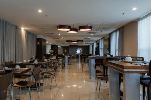 une salle à manger avec des tables et des chaises dans un restaurant dans l'établissement eSuites Belo Horizonte Minascasa, à Belo Horizonte