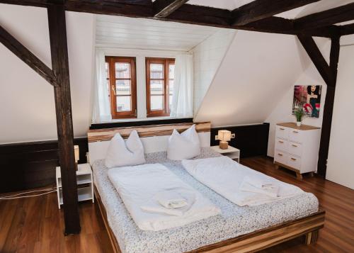 um quarto com uma cama com lençóis brancos e almofadas em Trobischhof em Dresden