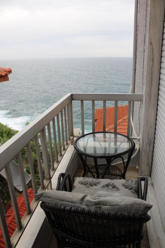 een tafel en een stoel op een balkon met uitzicht op de oceaan bij Kalys House in Kavala