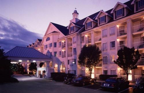 een groot wit gebouw met auto's geparkeerd voor het bij Hotel Grand Victorian in Branson