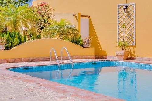 a swimming pool with blue water in a resort at Quinta Almargem Lusitano - Farm House in Tavira