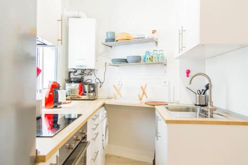 - une cuisine blanche avec des placards blancs et un évier dans l'établissement Céntrico apartamento bien ubicado para 5, 3 Hab, à Alcobendas