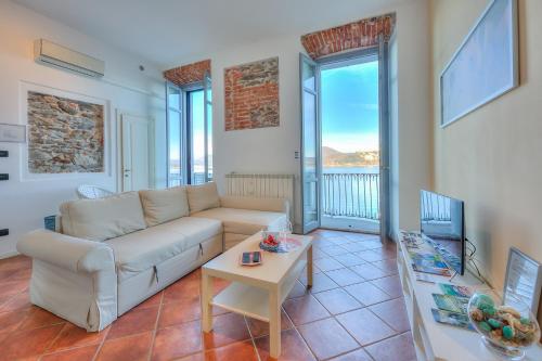 ein Wohnzimmer mit einem Sofa und einem Tisch in der Unterkunft Aparthotel Arona - Happy Rentals in Arona