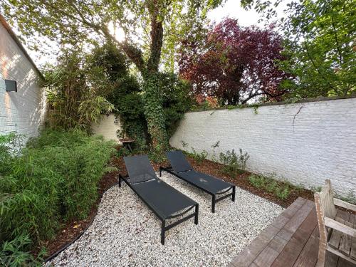 two black chairs and a table in a garden at Luxury Apartment with Cosy Garden! in Ghent