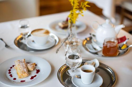 een tafel met borden en kopjes koffie bij Hotel Radun in Luhačovice