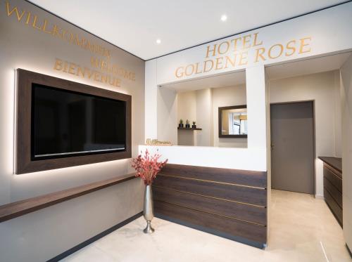 un hall d'hôtel avec une télévision et une rangée de colabres dans l'établissement Hotel Goldene Rose, à Heidelberg