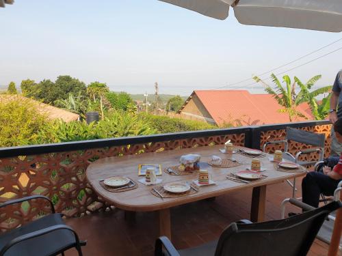 uma mesa numa varanda com comida em Alison & Dave's Guesthouse em Entebbe