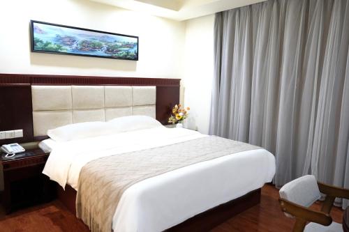 um quarto de hotel com uma cama grande e uma televisão na parede em Huahang Hotel - Guangzhou Baiyun International Airport - Free airport shuttle bus em Guangzhou