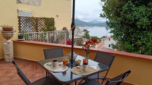 a table and chairs on a balcony with a view of the water at Il Girasole in Gaeta