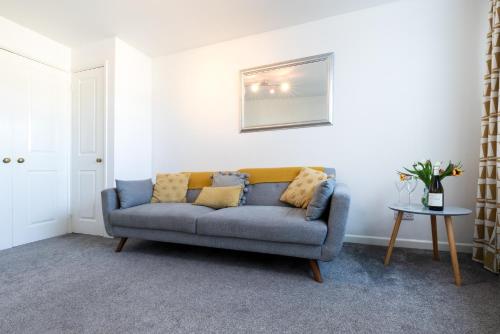 un soggiorno con divano blu e tavolo di Little Nook Apartment a St Ives