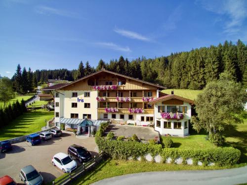 un gran edificio con coches estacionados en un estacionamiento en Ferienhotel Iris, en Auffach