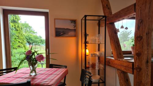 a dining room table with a vase of flowers on it at Ferienwohnung Peetsch am See in Mirow