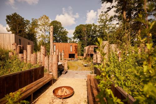 een tuin met een houten kom op de grond bij Dutchen Zeegser Duinen Villalodges in Zeegse