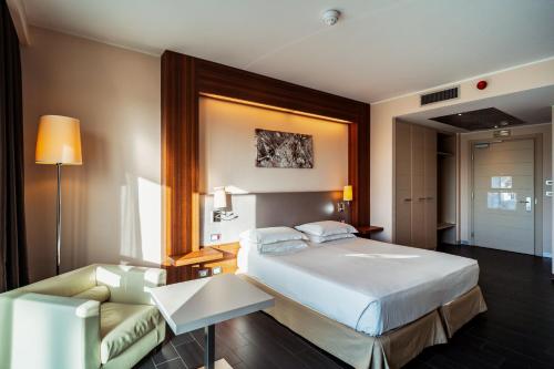 a hotel room with a bed and a couch at Delta Hotels by Marriott Olbia Sardinia in Olbia