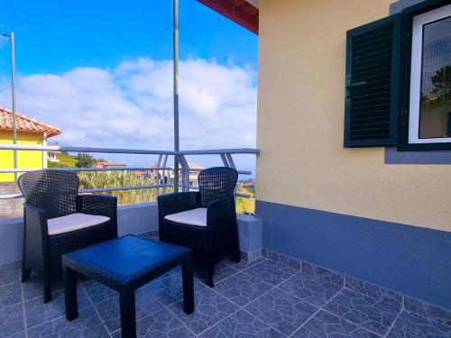 un patio con sillas, una mesa y una ventana en Sea and Mountain Views in the Heart of Santana, Christmas and New Year, en Santana