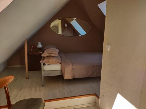 ein kleines Schlafzimmer mit einem Bett und einem Spiegel in der Unterkunft Loft 'PRL' in Tykocin