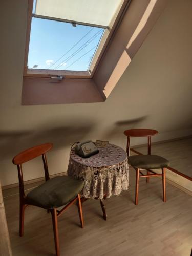 Zimmer mit einem Tisch, 2 Stühlen und einem Fenster in der Unterkunft Loft 'PRL' in Tykocin