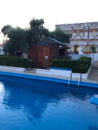 a pool of water with a building in the background at IL MIO PARADISO in Porto Cesareo