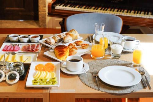 een tafel met borden ontbijtproducten en een piano bij Solar das Bouças in Amares