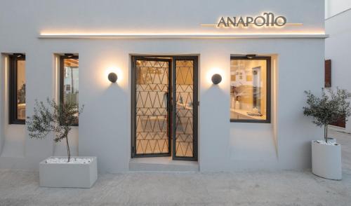 a white building with a door and two potted plants at Anapollo Boutique Hotel Adults Only in Naxos Chora