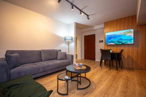 uma sala de estar com um sofá e uma mesa em Blloku Unique Apartments 2 em Tirana