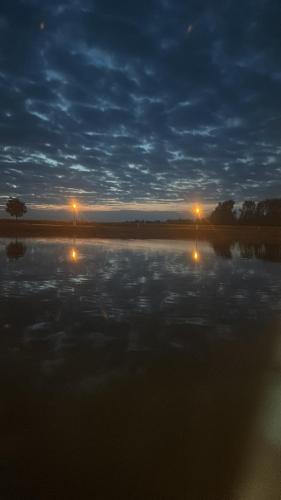 - une vue nocturne sur un lac avec des lumières dans l'eau dans l'établissement Appartement port dienville, à Dienville