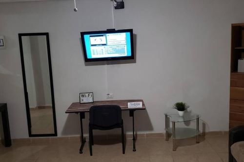 een tafel met een stoel en een televisie aan een muur bij Departamento Comodo centrico Tv Ac wifi cocina parking, letra C in Ciudad Valles