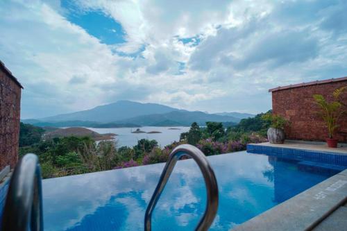 una piscina con vistas al río y a las montañas en CONTOUR ISLAND RESORT & SPA by CITRINE, en Tariyod