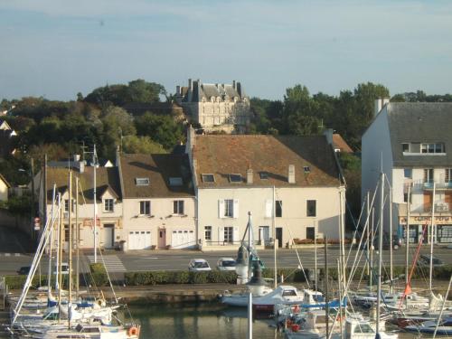 a group of boats docked in a harbor with a castle at Chateau de Courseulles in Courseulles-sur-Mer