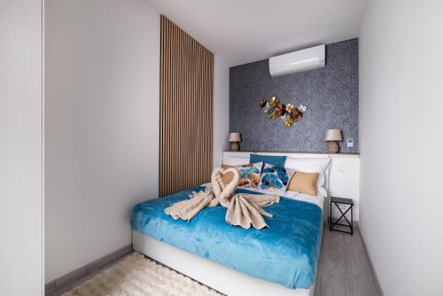 een slaapkamer met een blauw bed met een handdoek erop bij Rames-Cosmo Downtown Apartment with rooftop POOL in Boedapest