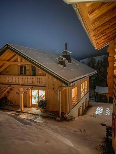 une grande maison en bois avec un toit en métal dans l'établissement 1000 Borne Caffe Hebergements Insolites, à Entremont