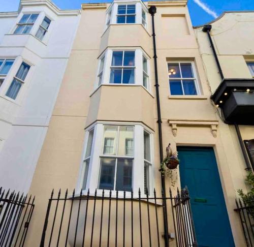 een gebouw met een blauwe deur en een hek bij Regency Grade II Listed Townhouse by Centre and Beach in Brighton & Hove