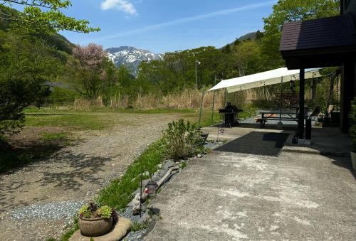 un refugio de picnic con una mesa de picnic en un campo en Mominoki Lodgeモミの木ロッジ, en Minakami